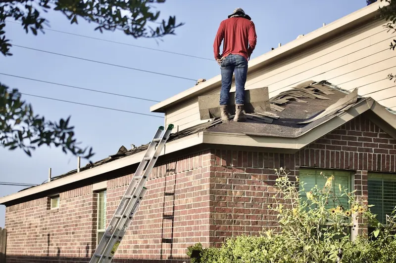Professional roofer working on a residential roof in Zanesfield